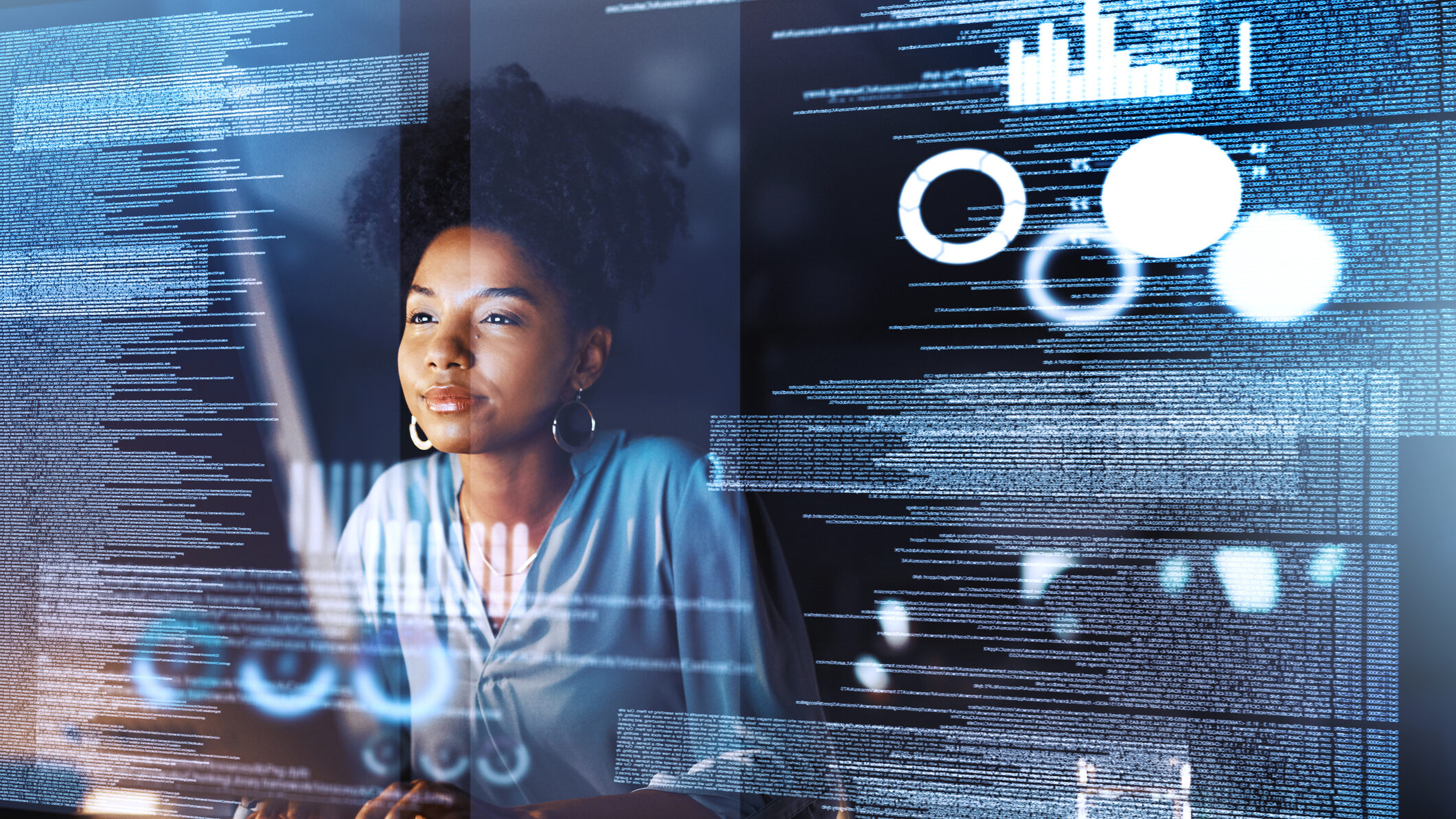 Woman analyzing digital data on transparent screens, expression focused, surrounded by graphs and code