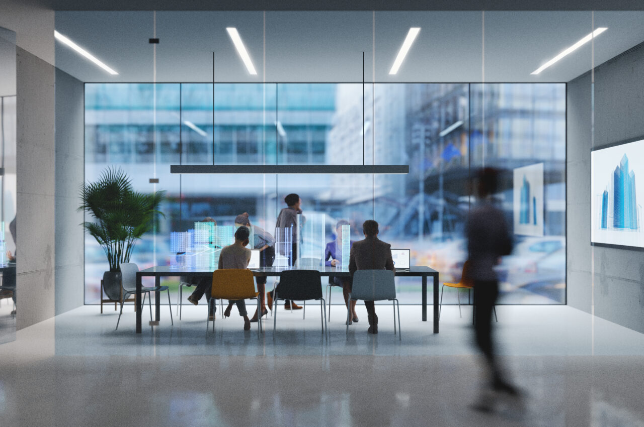 People in a modern office with large glass windows, working collaboratively