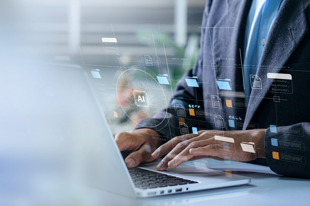 Businessperson typing on a laptop with digital AI graphics overlaying the screen
