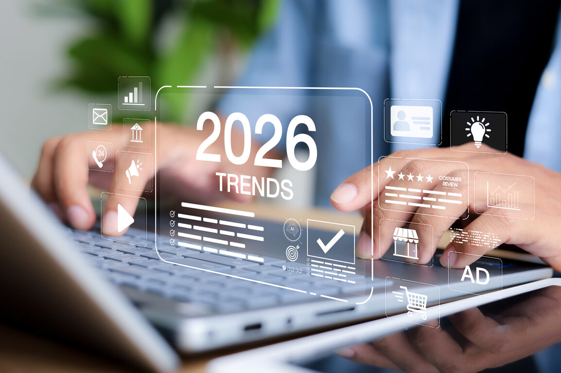 Holographic display showing "2026 Trends" above a laptop with business icons